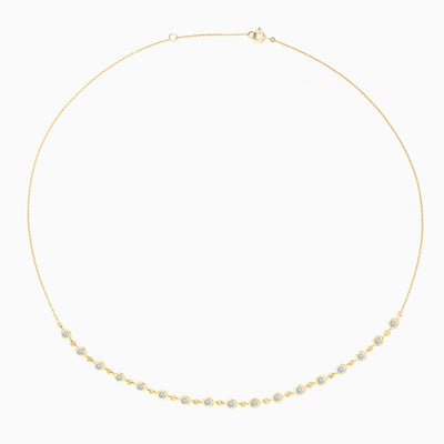 ESSENTIAL BEZEL HALF TENNIS NECKLACE is a bezel set diamond tennis necklace in 18kt yellow gold