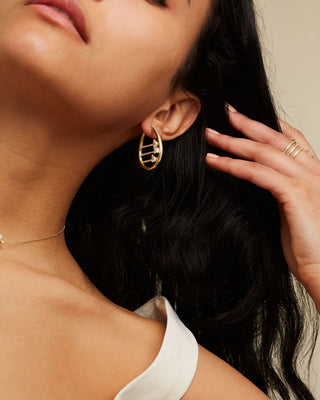 Dizzy Abacus earrings in 18kt yellow gold worn on woman