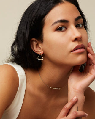 Dizzy Love Triangle Earrings been worn by a woman with the matching Dizzy Slide Necklace, both made in 18kt gold white gold. 