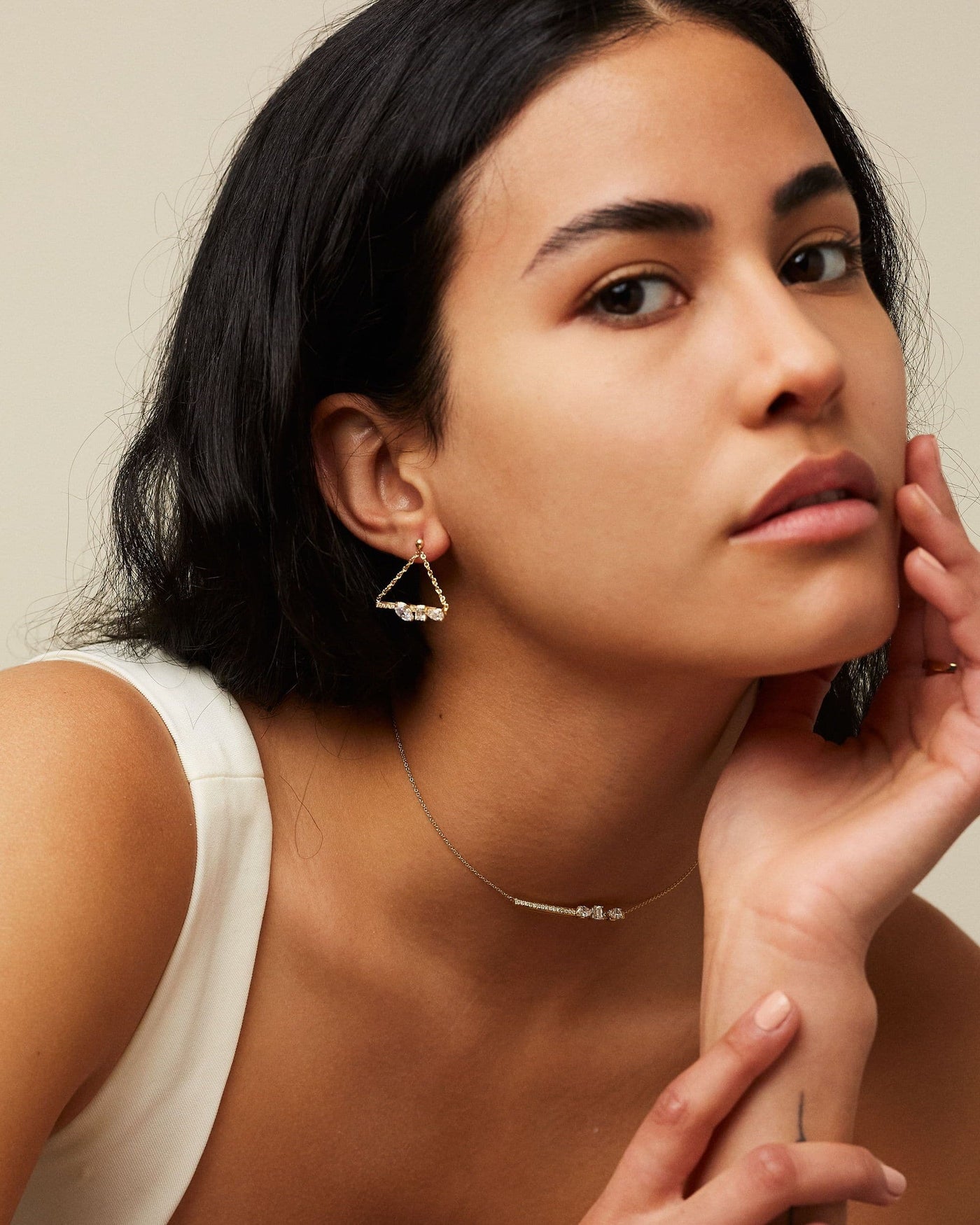 Dizzy Love Triangle Earrings been worn by a woman with the matching Dizzy Slide Necklace, both made in 18kt gold white gold. 