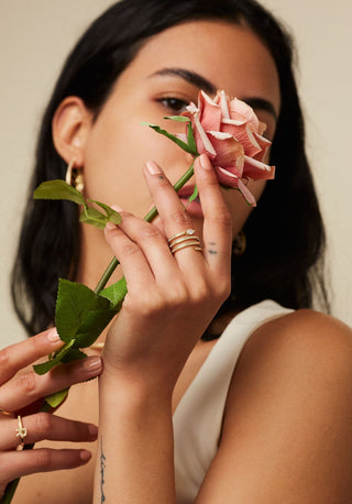 Dizzy Twirl Ring is made in 18kt yellow gold, it has a spiralling diamond line leading to a marquise diamond at the end worn by woman.